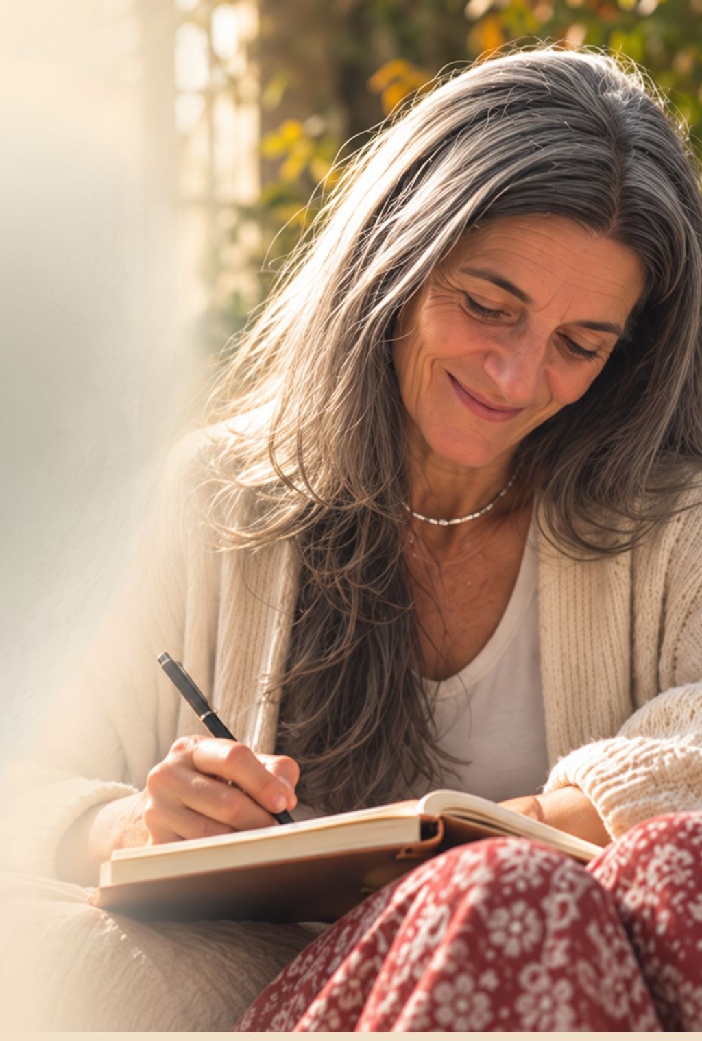 Ángela Mazeres sonriendo mientras escribe en un cuaderno, con luz natural
